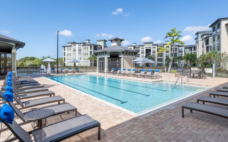 a pool with lounge chairs around it